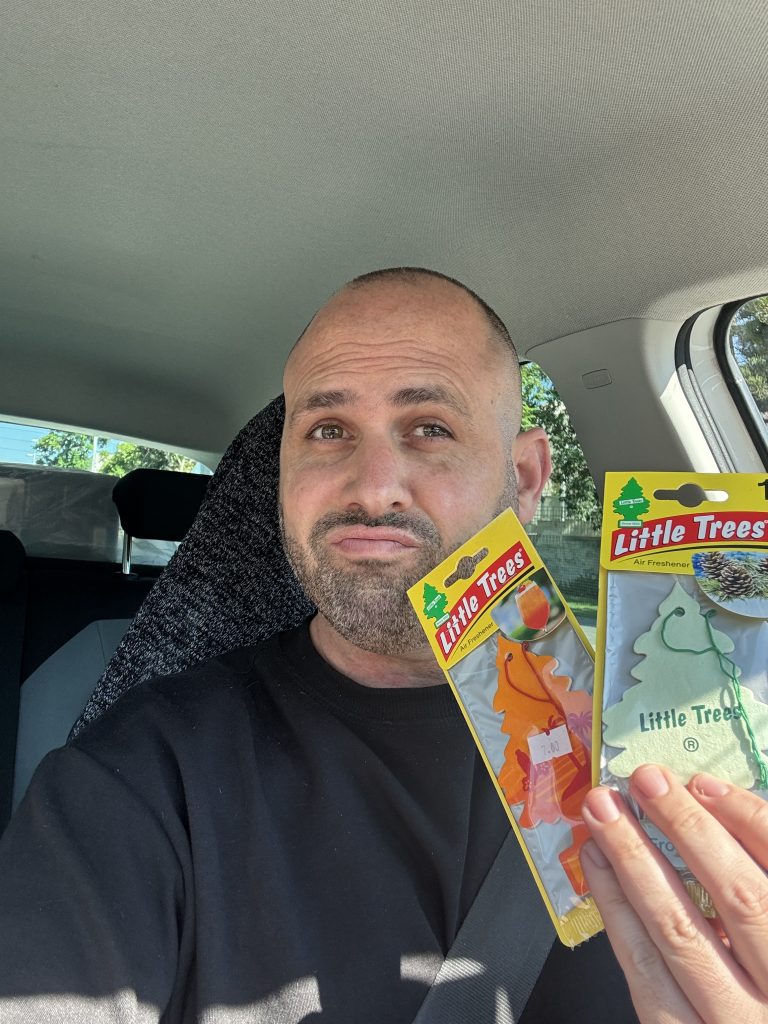 עומר ברק במכונית מחזיק שני עצי ריח שקיבל במתנה